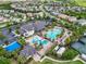 Aerial view of a community pool with a water slide and various lounge chairs and palm trees surrounding the facility at 2165 Hollow Forest Ct, Wesley Chapel, FL 33543
