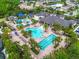 Aerial view of the community pool and waterpark area including palm trees, lounge seating, and parking at 2165 Hollow Forest Ct, Wesley Chapel, FL 33543