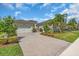 Paver driveway leading to a well-maintained home with a lush lawn and mature landscaping at 2165 Hollow Forest Ct, Wesley Chapel, FL 33543