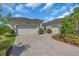 Spacious three car garage with paver driveway and meticulously maintained landscaping at 2165 Hollow Forest Ct, Wesley Chapel, FL 33543