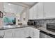 A modern kitchen area featuring granite countertops and sleek white cabinetry at 2165 Hollow Forest Ct, Wesley Chapel, FL 33543