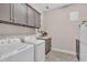 Functional laundry room featuring gray cabinets, modern appliances, and laminate countertops at 2165 Hollow Forest Ct, Wesley Chapel, FL 33543