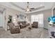 Spacious living room with a ceiling fan, a shag rug, and comfortable leather furniture at 2165 Hollow Forest Ct, Wesley Chapel, FL 33543