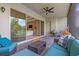Relaxing covered patio featuring ceiling fan and comfortable outdoor seating with view to the home's bright living room at 2165 Hollow Forest Ct, Wesley Chapel, FL 33543