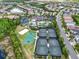 Aerial view of the community tennis and basketball courts, as well as scenic ponds and surrounding greenery at 2165 Hollow Forest Ct, Wesley Chapel, FL 33543