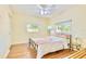 Bright bedroom features wood floors, comfortable bed with colorful linens, and natural light from two windows at 2501 Crescent Dr, Largo, FL 33770