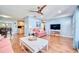 Cozy living room features hardwood floors, soft blue walls, comfortable seating, and a modern ceiling fan at 2501 Crescent Dr, Largo, FL 33770