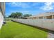 Well-maintained backyard featuring lush artificial turf and a white privacy fence with string lights at 2511 Early Dawn Ct, Valrico, FL 33594