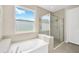 Spa-like bathroom with a soaking tub, glass-enclosed shower, and natural light, providing a serene and relaxing atmosphere at 2511 Early Dawn Ct, Valrico, FL 33594