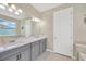 Bright bathroom featuring a double vanity with gray cabinetry and a large mirror at 2511 Early Dawn Ct, Valrico, FL 33594