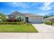Inviting single-story home with lush landscaping and a gray exterior, complemented by a brick paver driveway at 2511 Early Dawn Ct, Valrico, FL 33594