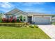 Charming single-story home with a well-manicured lawn, colorful flowers, and a brick paver driveway at 2511 Early Dawn Ct, Valrico, FL 33594