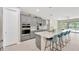 Modern kitchen features gray cabinetry, an island with quartz countertop, stainless steel appliances, and a decorative backsplash at 2511 Early Dawn Ct, Valrico, FL 33594
