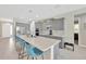 This kitchen showcases gray cabinets, stainless steel appliances, an island with seating, and a view of the dining area at 2511 Early Dawn Ct, Valrico, FL 33594