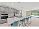 Bright kitchen showcases gray cabinets, stainless appliances, an island with seating, and views to an open living space at 2511 Early Dawn Ct, Valrico, FL 33594