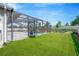 A beautiful screened-in pool and patio area with a well-maintained lawn and white fence surrounding the property at 2511 Early Dawn Ct, Valrico, FL 33594