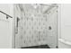 A frameless glass shower features black and white tilework and modern shower fixtures at 2650 Countryside Blvd # C203, Clearwater, FL 33761