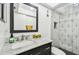 Updated bathroom with framed mirror and elegant sink with decorative shower at 2650 Countryside Blvd # C203, Clearwater, FL 33761