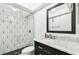 The bathroom has a black and white vanity, hexagon tiles, and a shower with a patterned glass door at 2650 Countryside Blvd # C203, Clearwater, FL 33761