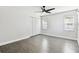 The bedroom includes gray wood floors, a ceiling fan, a closet, and two windows with blinds at 2650 Countryside Blvd # C203, Clearwater, FL 33761