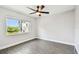 Cozy bedroom with a window view and gray wood-look flooring at 2650 Countryside Blvd # C203, Clearwater, FL 33761