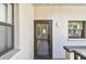 Exterior view of unit 203, featuring a neutral-colored wall, a small window and the front door at 2650 Countryside Blvd # C203, Clearwater, FL 33761