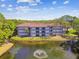 Exterior view of the condos nestled on the water, highlighting the water feature and manicured landscape and scenic views at 2650 Countryside Blvd # C203, Clearwater, FL 33761