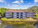 Exterior view of condo building near water with private balconies, showcasing peaceful waterfront living and serene surroundings at 2650 Countryside Blvd # C203, Clearwater, FL 33761