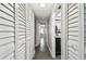 Hallway with gray wood-look floors leading to an updated bathroom at 2650 Countryside Blvd # C203, Clearwater, FL 33761