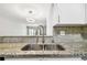 Close-up of a kitchen sink featuring granite countertops and views of the dining room and natural sunlight at 2650 Countryside Blvd # C203, Clearwater, FL 33761