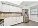 Updated kitchen with granite countertops, stainless steel refrigerator, white cabinets, and hardwood-style floors at 2650 Countryside Blvd # C203, Clearwater, FL 33761