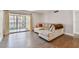 Comfortable living room with neutral paint, sliding glass doors, and a cozy couch at 2650 Countryside Blvd # C203, Clearwater, FL 33761