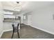 Bright living room features gray wood-look flooring, modern lighting fixture and an open floor plan at 2650 Countryside Blvd # C203, Clearwater, FL 33761