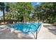 Community pool with plenty of lounge chairs and tables offers an inviting space for relaxation and recreation surrounded by landscaping at 2650 Countryside Blvd # C203, Clearwater, FL 33761