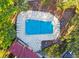 Aerial view of community pool featuring many lounge chairs, tables, meticulously landscaped foliage and privacy fencing at 2650 Countryside Blvd # C203, Clearwater, FL 33761