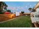 Spacious backyard featuring a large grassy area, string lights, projector screen and wooden fence at 2704 W Main St, Tampa, FL 33607