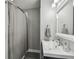The bathroom features a vanity, mirror, shower with a gray curtain, and tiled floor at 2704 W Main St, Tampa, FL 33607