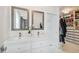 Bathroom featuring a double vanity with framed mirrors and a glimpse into a walk-in closet with storage at 2704 W Main St, Tampa, FL 33607