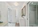 Bright bathroom featuring a double sink vanity, neutral tile, and glass enclosed shower at 2704 W Main St, Tampa, FL 33607