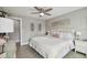 Cozy bedroom showcasing a tufted headboard bed, neutral walls, a ceiling fan, and natural light from the window at 2704 W Main St, Tampa, FL 33607