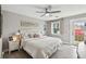 Comfortable bedroom with a tufted headboard, soft colors, natural light, and a decorative ceiling fan at 2704 W Main St, Tampa, FL 33607
