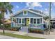 Charming blue two-story home featuring a cozy front porch, complemented by a well-manicured front yard at 2704 W Main St, Tampa, FL 33607