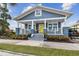 Charming home featuring a welcoming front porch, blue siding, white trim, and a cheerful yellow front door at 2704 W Main St, Tampa, FL 33607