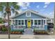 Charming blue two-story home with a welcoming yellow front door and beautifully landscaped front yard at 2704 W Main St, Tampa, FL 33607