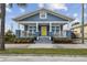 Inviting home boasting a spacious front porch, blue siding, white trim, and colorful landscaping at 2704 W Main St, Tampa, FL 33607