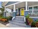 Close-up of front steps with colorful tile details, potted plants, and a bright yellow door at 2704 W Main St, Tampa, FL 33607