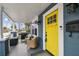 Welcoming front porch with comfortable seating, grill, and bright yellow door under a sunny sky at 2704 W Main St, Tampa, FL 33607