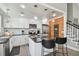 Bright kitchen features white cabinetry, a black countertop island with bar seating, and modern stainless steel appliances at 2704 W Main St, Tampa, FL 33607