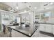 Bright kitchen featuring white cabinetry, stainless steel appliances, black countertops and a chandelier over a dining area at 2704 W Main St, Tampa, FL 33607