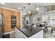 Open kitchen featuring a large island with a black countertop, stylish pendant lights, and a charming wooden accent wall at 2704 W Main St, Tampa, FL 33607